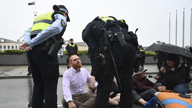 Police move in after protesters blocked the road in front of Parliament House in Canberra. Picture: NewsWire / Martin Ollman