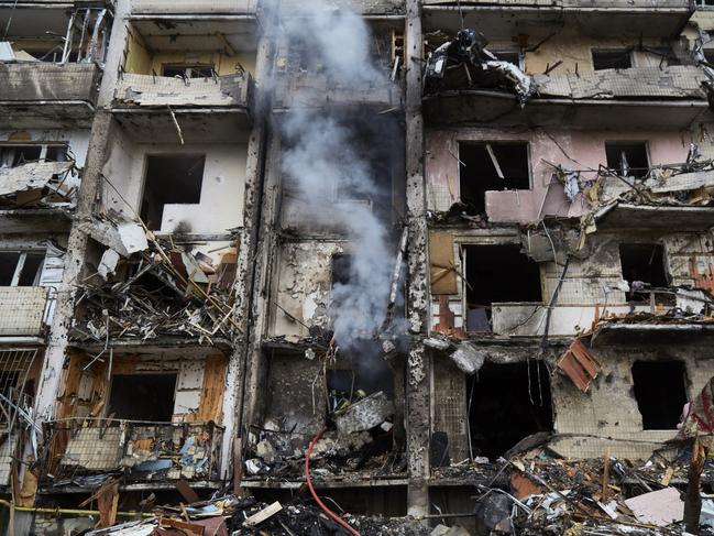 Firemen extinguish a fire inside a residential building that was hit by a missile in Kyiv.