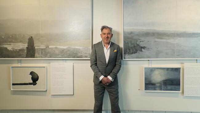 Luke Wagner, left, among the painting of his exhibition describing the poems from James McAuely's book, Time Given. Steve McAuley, son of the poet, returned to Hobart for Luke's exhibition opening. Picture: MATHEW FARRELL