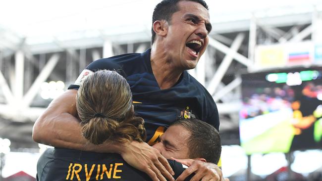 Tim Cahill and Jackson Irvine celebrate James Troisi’s goal.