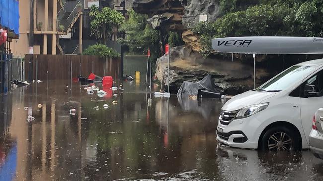 Blocked drains and a heavy downfall just after 8am led to flooding in Kangaroo Lane in Manly on Tuesday, leaving garbage bins and their contents floating in the floodwater. Picture: Jim O'Rourke