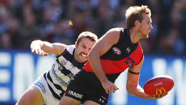 Darcy Parish finds a way past Tom Atkins of the Cats. Picture: Michael Klein