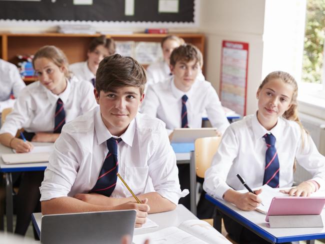 Students Listening To Female Teacher In Classroom