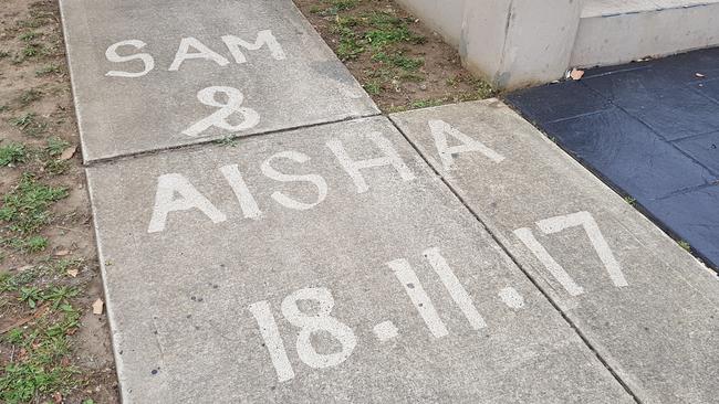 The bride and grooms names scrawled on the footpath outside the Merrylands home. Picture: Steve Tyson