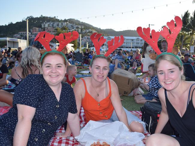 (From left) Meghan Gibson, Laura Goff and Tabitha Field at the Rotary Carols by the Beach 2019 on the Airlie Foreshore.