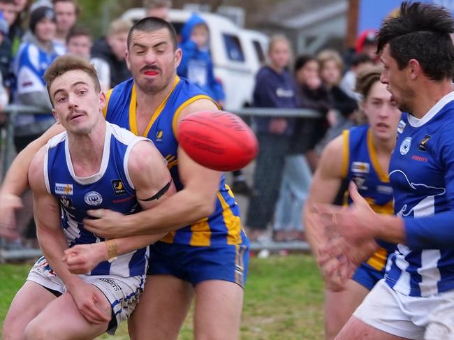 A Langwarrin player is tackled as Mark Baguley is about to receive the ball. Picture: Paul Stanley Churcher