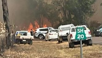 Cars pull off the road as fire crews battle a fire along Cox Peninsula Rd on Friday night. Source: Wagait Beach Community.