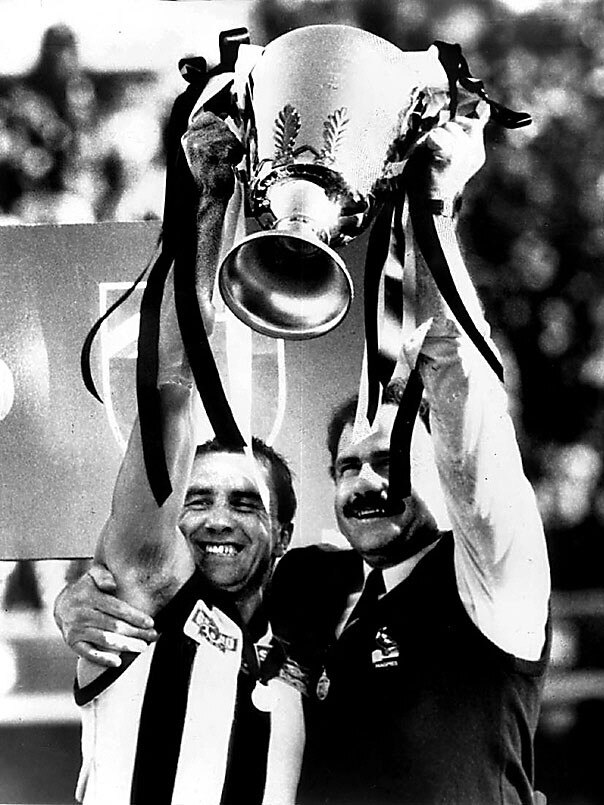 Leigh Matthews and Tony Shaw hold the 1990 Premiership Cup aloft.