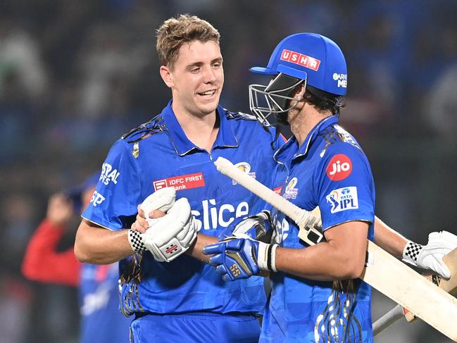Mumbai Indians' Cameron Green (L) hugs teammate Tim David after their win in the Indian Premier League (IPL) Twenty20 cricket match between Delhi Capitals and Mumbai Indians at the Arun Jaitley Stadium in New Delhi on April 11, 2023. (Photo by Sajjad HUSSAIN / AFP)
