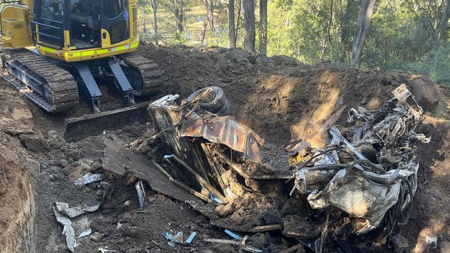 An excavator digs up truck at the Menangle property. Picture: NSW Police