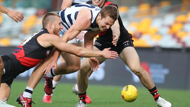 Geelong’s Tom Atkins outworks Bombers Dyson Heppell and Zach Merrett. Picture: Jono Searle/AFL Photos/via Getty Images