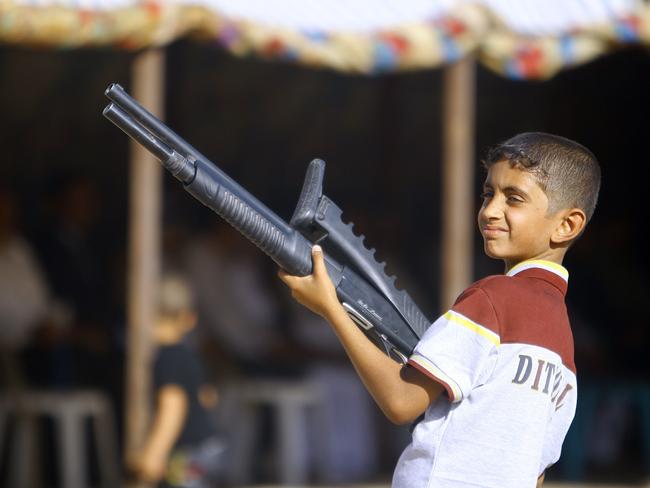An Iraqi boy holds a weapon as he takes part in a gathering by Shiite tribesman to show their willingness to join Iraqi security forces in the fight against Jihadist militants. AFP PHOTO/HAIDAR HAMDANI