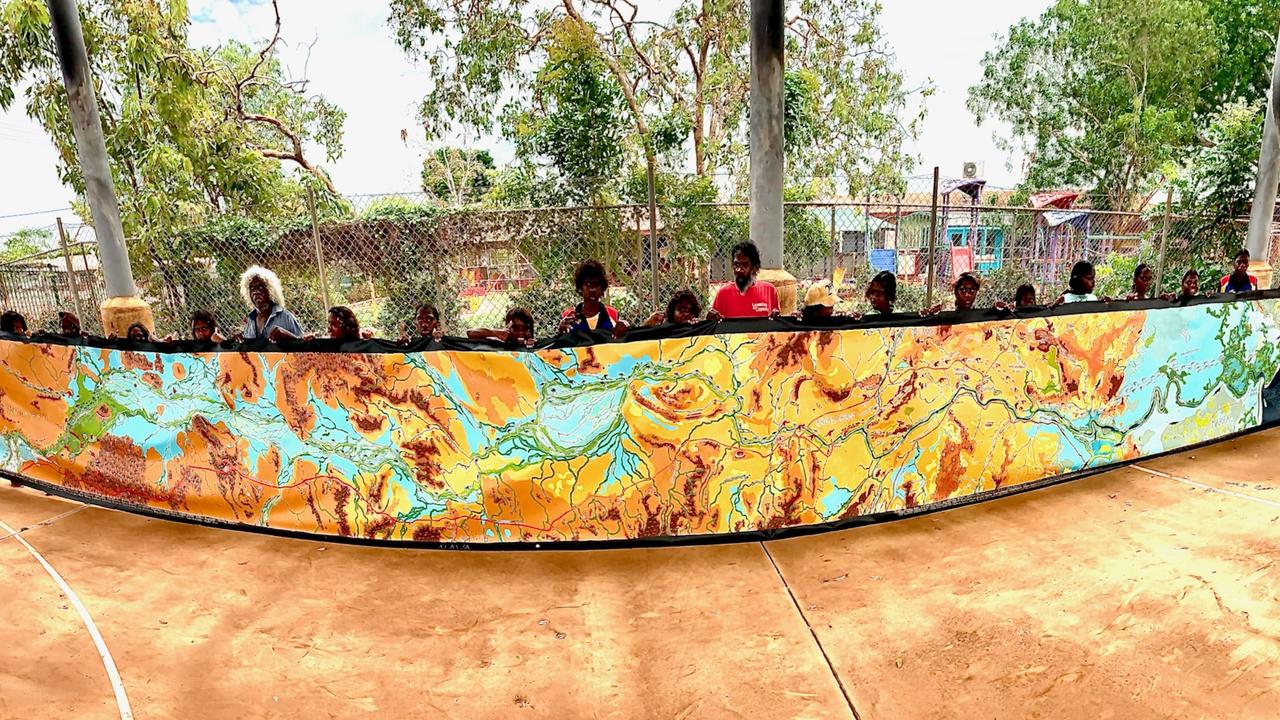 Children at the Ngukurr School holding the cultural songlines map of the Roper River. Picture: Supplied/Sasha Pavey.