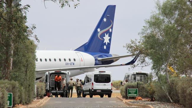 October 27: Prisoners prepare to board a chartered flight to Darwin at Alice Springs Airport, where they will be rehoused to Darwin Correctional Centre. Picture: Gera Kazakov