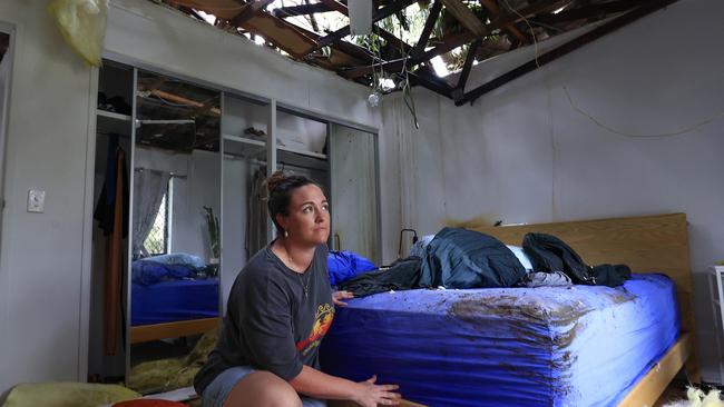 Lizzy Burke tries to clean up her Elanora home after a tree went through the roof. Picture: Adam Head