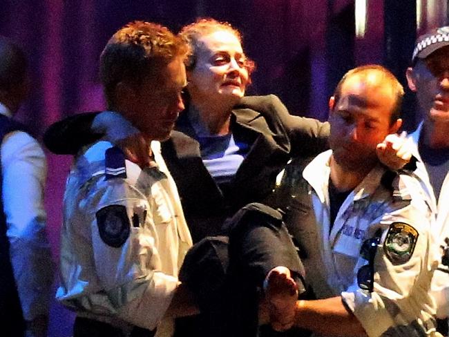 Marcia Mikhael is led out of the cafe by police after the siege had ended. She suffered a gunshot wound to her leg. Picture: Joosep Martinson/Getty Images