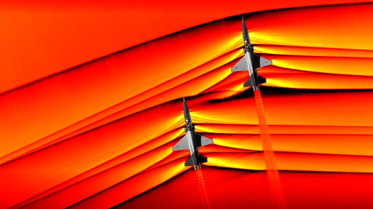 Two T-38 aircraft flying in formation at supersonic speeds producing shockwaves that are heard on the ground as a sonic boom. NASA has been able to “see” the shockwaves moving around the planes. Picture: AFP/NASA