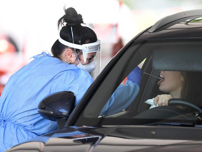 BRISBANE, AUSTRALIA - NewsWire Photos - DECEMBER 16, 2021. A health worker swab a woman at a Covid-19 testing clinic in Murarrie as Queensland wrangles with the potential spread of the Omicron variant in the community.Picture: NCA NewsWire / Dan Peled