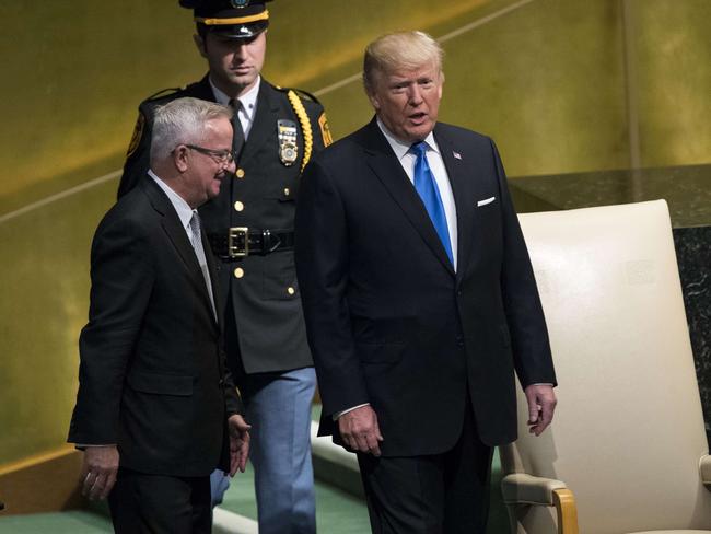 Mr Trump is escorted by protocol officials as he arrives onstage to address the United Nations General Assembly. Picture: Drew Angerer/Getty Images/AFP