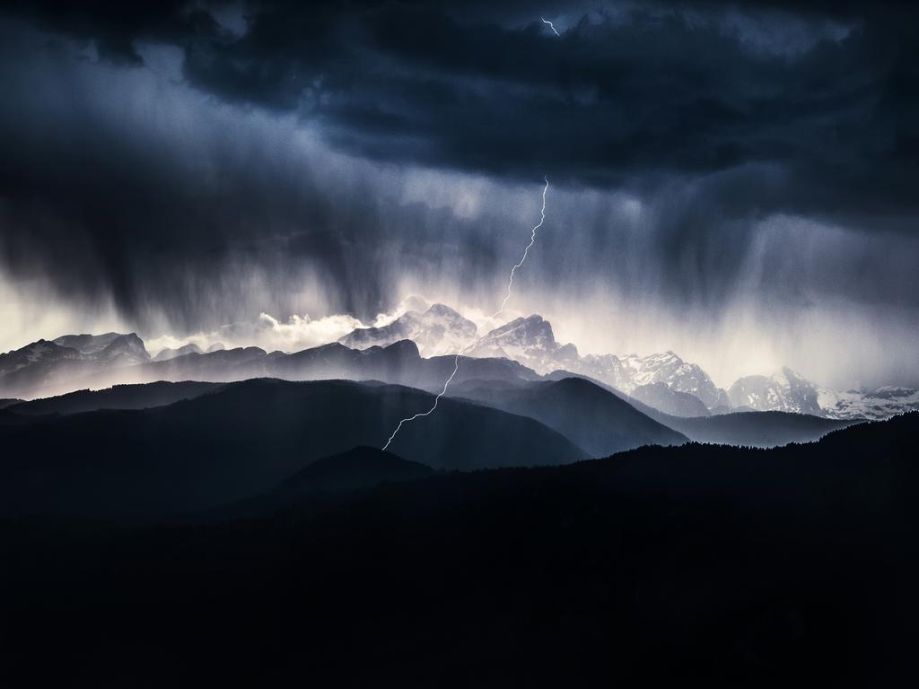 Drama in the Mountains. Photographer: Ales Krivec Year: 2018 “The image was taken from a local hill called Ajdna, which I often visit when I don’t have time for longer trips to the Alps. It offers great views towards Julian Alps and Slovenia’s highest mountain, Triglav. When I got to the top the storm was just passing above Mt. Triglav. I wanted to catch the lightning so I set up my camera on intervalometer (1 second intervals) and captured about 500 images this way. Luckily, on one of the photos, the lightning was captured perfectly. There was a lot of drama in the sky, that’s why I went with a dark blue post processing to really emphasize all that was going on.” Copyright: © Ales Krivec, Slovenia, Entry, Open, Landscape &amp; Nature, 2018 Sony World Photography Awards