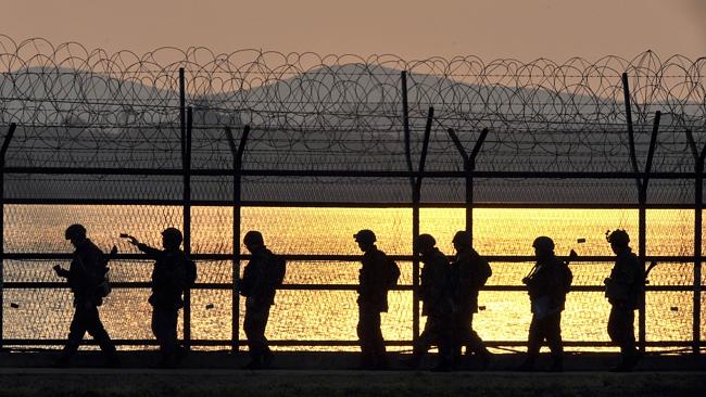 Keeping watch...South Korean soldiers patrol along a military fence near the Demilitarised zone (DMZ) dividing the two Koreas...