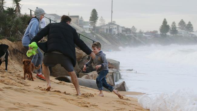 People running away from the huge swells on the shore. Picture: David Swift