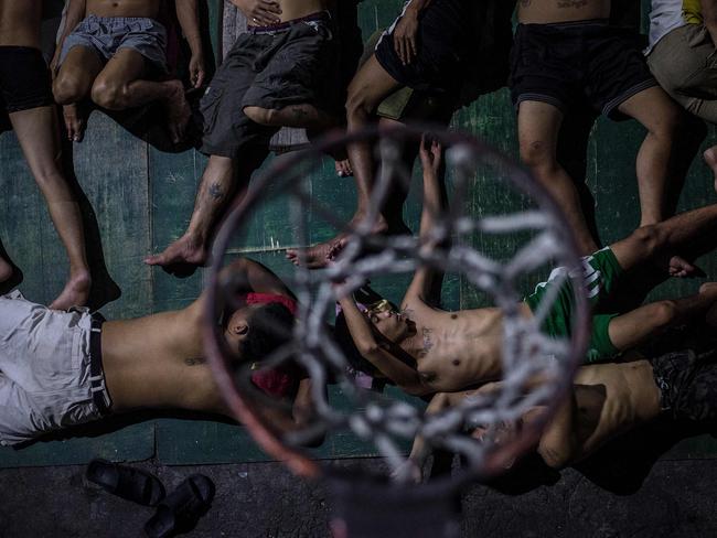 Inmates sleep on the ground of an open air basketball court inside the Quezon City jail at night in Manila. Picture: Ayee Macaraig