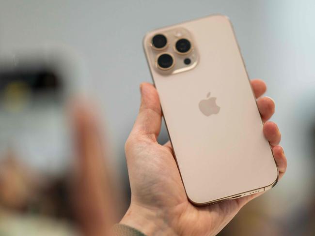 A person holds up a new iPhone 16 Pro following Apple's "It's Glowtime" event in Cupertino, California, September 9, 2024. (Photo by Nic COURY / AFP)