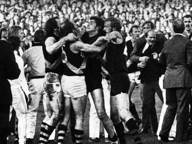 18/05/1974. Players, coaches, fans and officials get involved in the infamous 1974 Richmond and Essendon fracas at Windy Hill. Brawl. Football. Richmond team manager Graeme Richmond is pulled from the scuffle. Battle of Windy Hill. Richmond v Essendon. 1974. Richmond team manager Graeme Richmond (middle, in suit and tie) is pulled away. Tiger Wayne Walsh is pictured behind Richmond's right shoulder, teammate Bryan Wood is far left, while Bomber Laurie Moloney (wearing No. 34) is far right. Identifiable players in the scuffle are, from left, Ian Stewart, Paul Sproule (wearing No. 6) and Ken Fletcher.Neg: GE18284