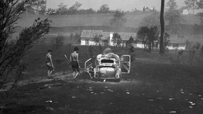 News / property 16/12/ 1951. A burned-out car lies in the wake of a bush and grassfire at Kenmore in Brisbane's west. The flames reached within two feet of the car owner's house in the background. Neg/no C73113 Picture by Bob Millar. Scanned October / 2009. The Courier-Mail Photo Archive