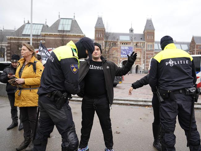 Police officers search people during a banned demonstration against the current corona policy in Amsterdam. Picture: AFP