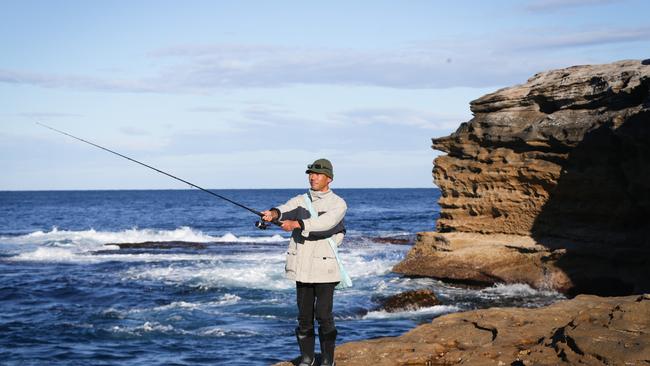 Fisherman Osamu Matsuda wears a life jacket when seas are rough at Little Bay in NSW.