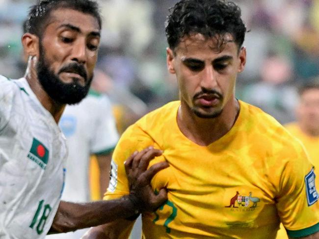 Australia's Daniel Arzani (R) fights for the ball with Bangladesh's Isa Faysal during the 2026 FIFA World Cup Asian qualification football match between Bangladesh and Australia at the Bashundhara Kings Arena in Dhaka on June 6, 2024. (Photo by MUNIR UZ ZAMAN / AFP)