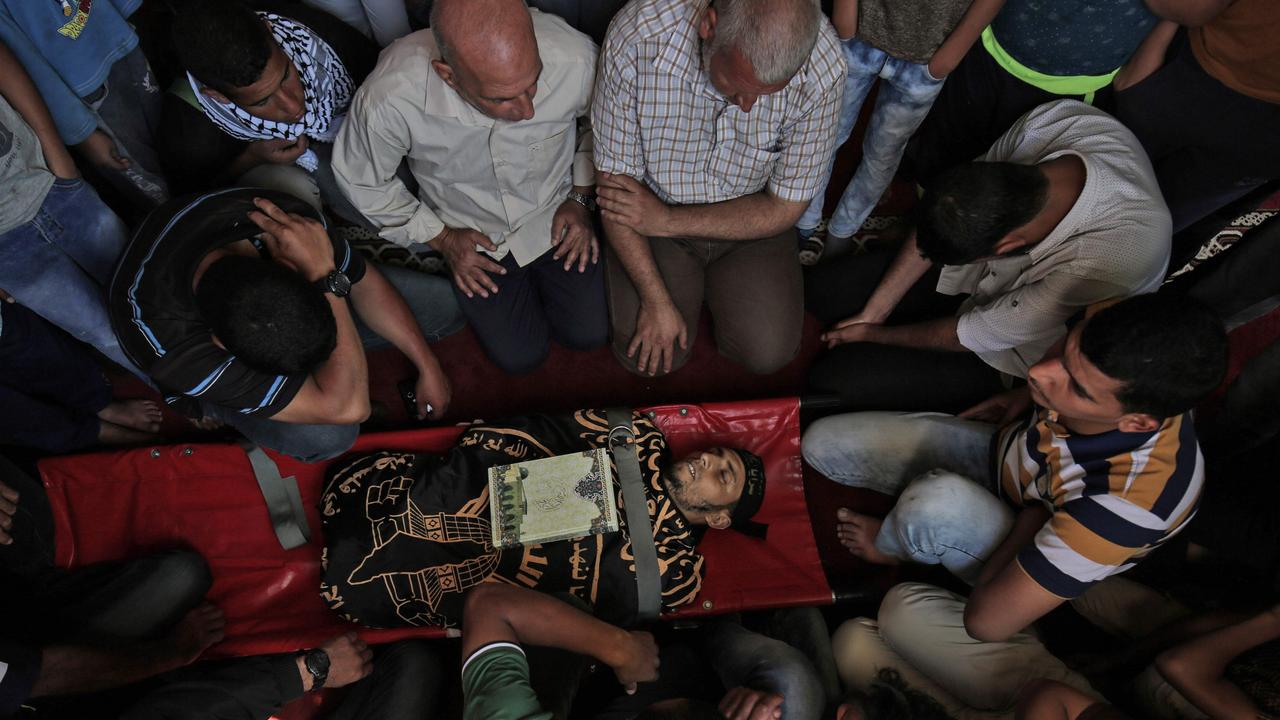 Palestinian mourners gather around the body of a man who was killed during the protests. Picture: AFP