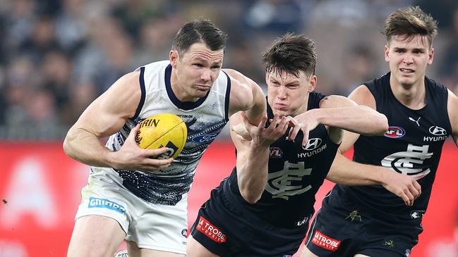 Patrick Dangerfield fends off Sam Walsh as he clears from the centre. Picture: Michael Klein