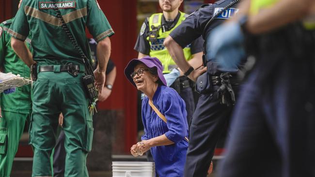 A protester surrounded by emergency services personnel after being unglued. Picture: Roy VanDerVegt