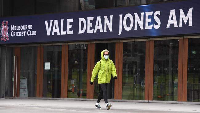 A pedestrian walks past a sign at the MCG remembering the champion Victorian.