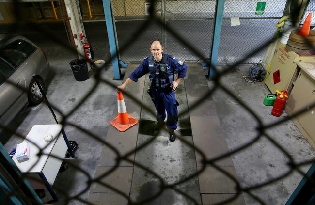 Crime Scene Section Acting Sergeant Tom Haydon at the vehicle hoist at the Gosford Police Station in 2015. Picture: Troy Snook