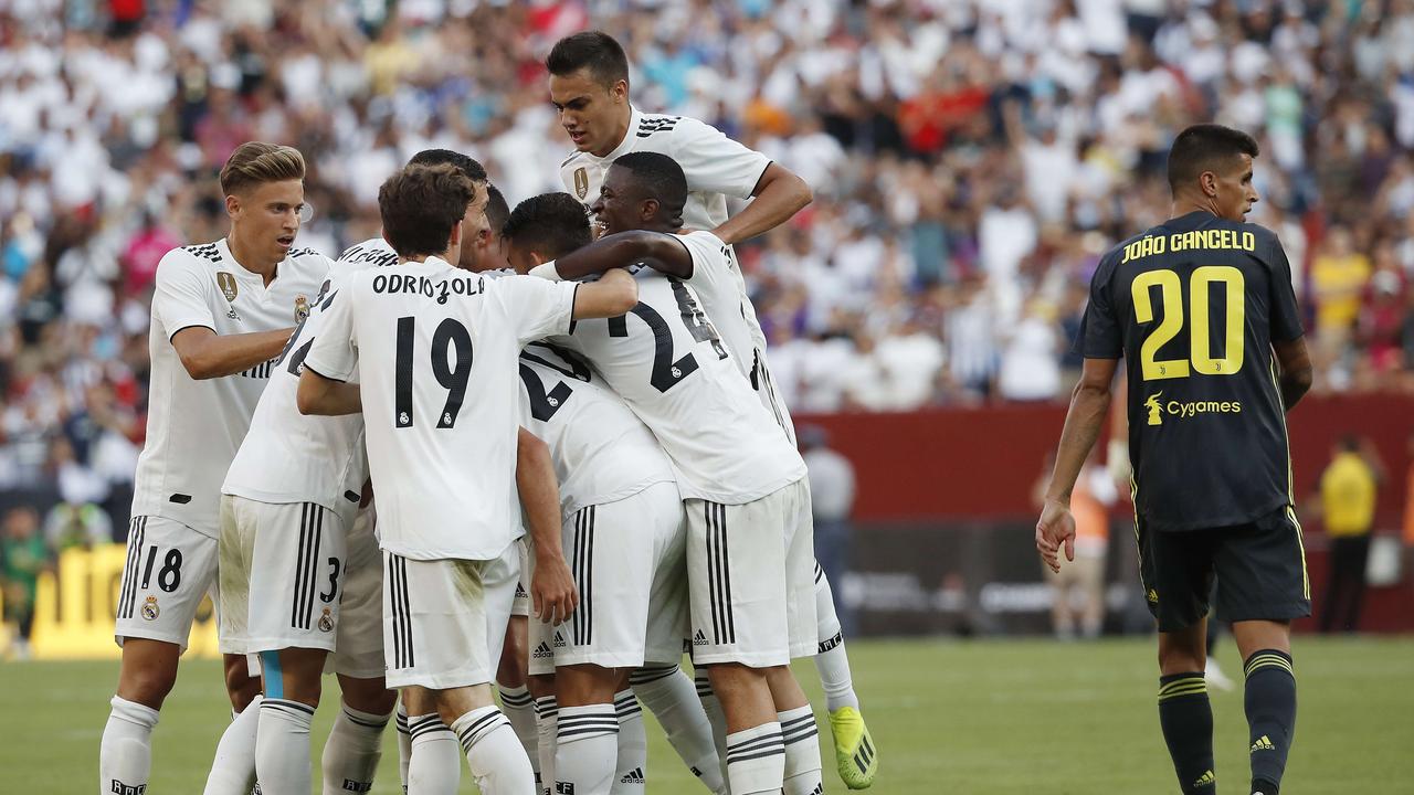 Marco Asensio is mobbed by his Real Madrid teammates after scoring.