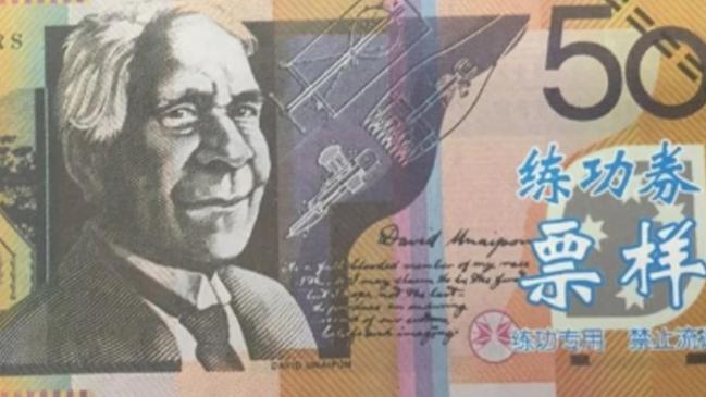 The notes were easily identifiable as counterfeit currency due to their containing large blue text in an Asian-language script on both sides.