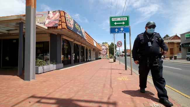 A police officer stands guard outside a pizza shop that copped the blame for a statewide lockdown. Picture: Getty Images