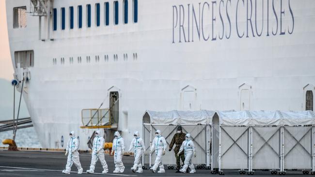 Emergency workers in protective clothing exit the Diamond Princess cruise ship at Daikoku Pier in Yokohama, Japan, in February 2020. (Photo by Carl Court/Getty Images)