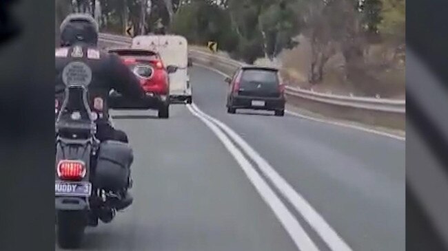 The Mitsubishi was captured weaving between lanes to overtake two cars while approaching a blind corner. Picture: 7NEWS