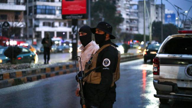 Fighters affiliated with Syria's new administration stand guard on the streets of Latakia after angry protests erupted in several areas around the country. Picture: AFP.