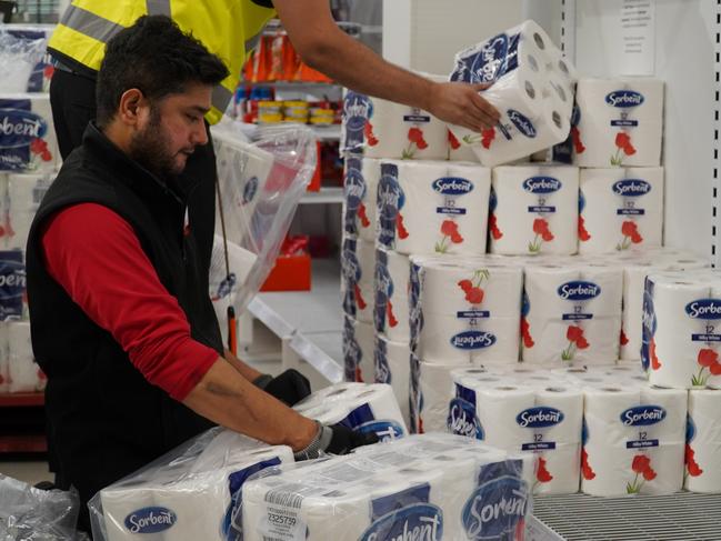 Coles workers restocking toilet paper. Picture: Coles