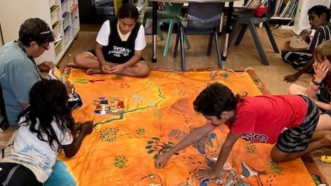 Sharon sits on the floor of her classroom surrounded by her students. Picture: Supplied