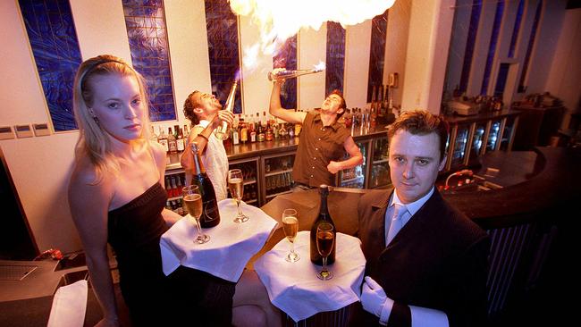 2003: Bartenders Matt Harmer and Jarrad Moore shoot flames while Leigh Segboer and GM Stephen Lee serve drinks.The staff at The Monastery were trained by professional butler coach. Picture: Derek Moore