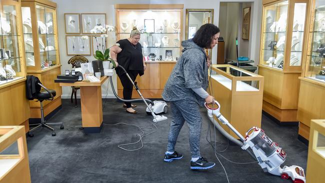 Workers clean up after the heist. Picture: Jake Nowakowski