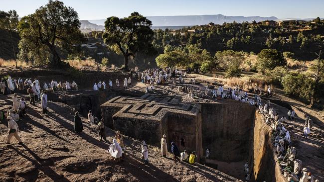 PIC FROM TARIQ ZAIDI / CATERS NEWS - (Pictured: Pilgrims surround the Church of St George in Lalibela, Ethiopia. Shaped like a Greek Orthodox cross, the Church of St George is perhaps the most famous of Lalibelas 13 churches. It was painstakingly excavated out of the rock, some 40 feet down, with hammer and chisel and built after King Lalibelas death by his widow as a memorial.) - A powerful photography series follows a pilgrimage to an ancient religious holy ground - but its not to Jerusalem or Mecca. Lalibela, in Ethiopia, is the site of intricate monolithic cave churches, hand-chiselled out of the towns red volcanic rock. The nondescript villages churches were chiselled hundreds of years ago, and to this day individuals, often barefoot, come from all over Ethiopia to visit. Photographer Tariq Zaidi visited Lalibela this year, documenting the mountain village and the pilgrims who flock there. - SEE CATERS COPY