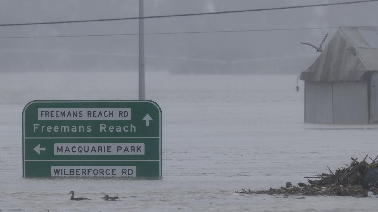 Road signs are seen submerged under floodwater along the Hawkesbury River near the Windsor Bridge in Sydney. (Photo by Jenny Evans/Getty Images)